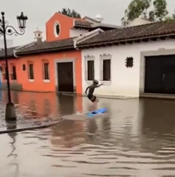 Joven surfea en inundación en Antigua Guatemala